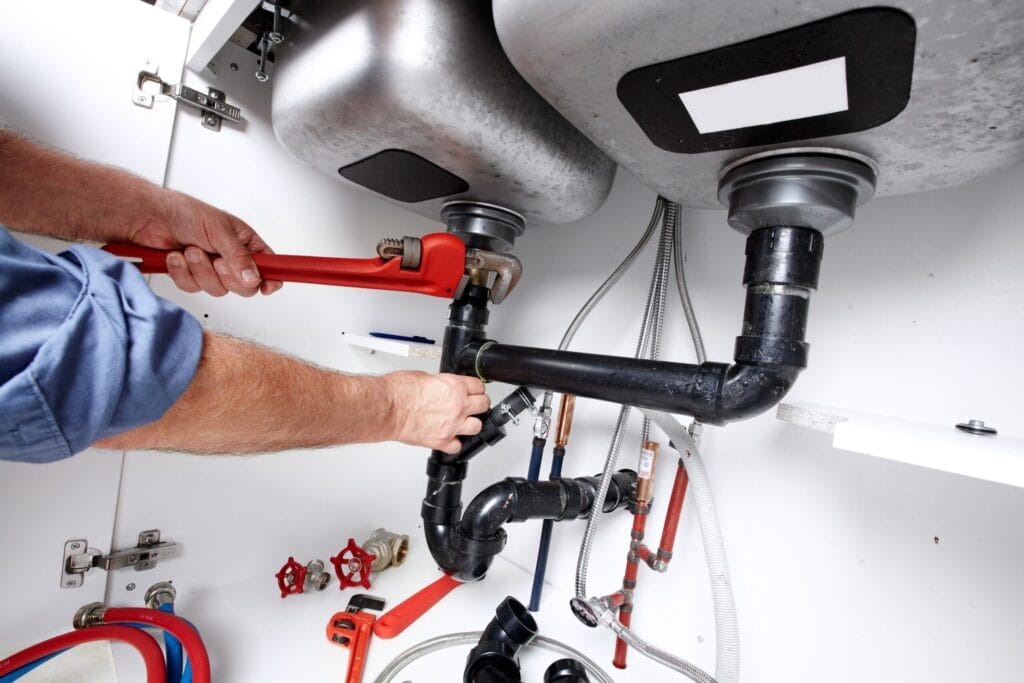 Tucker Plumbing Pros fixing under sink plumbing and drain pipes