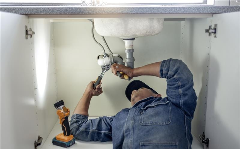 Plumber repairing kitchen sink drain pipes in Tucker, Georgia