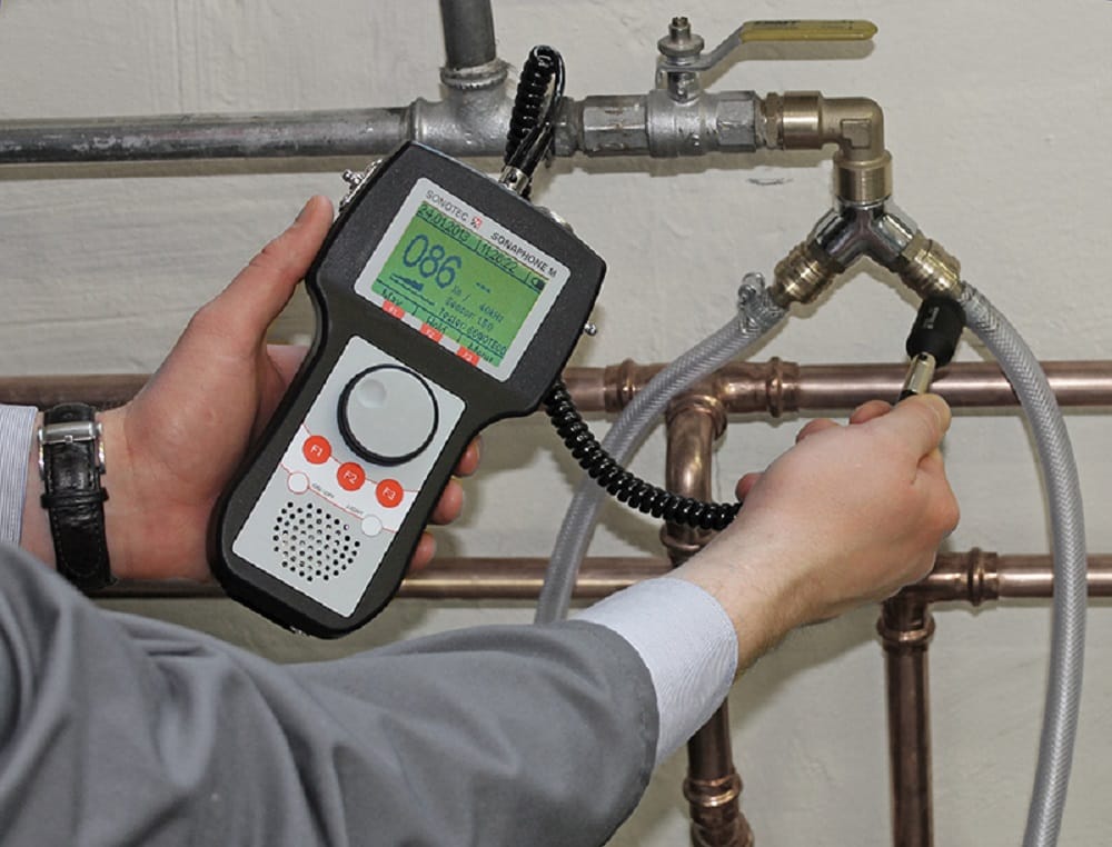 Plumber testing pipes with electronic leak detection equipment in Tucker