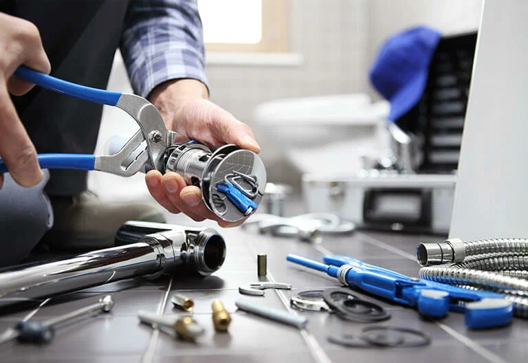 Technician repairing a plumbing fixture with professional tools in Tucker