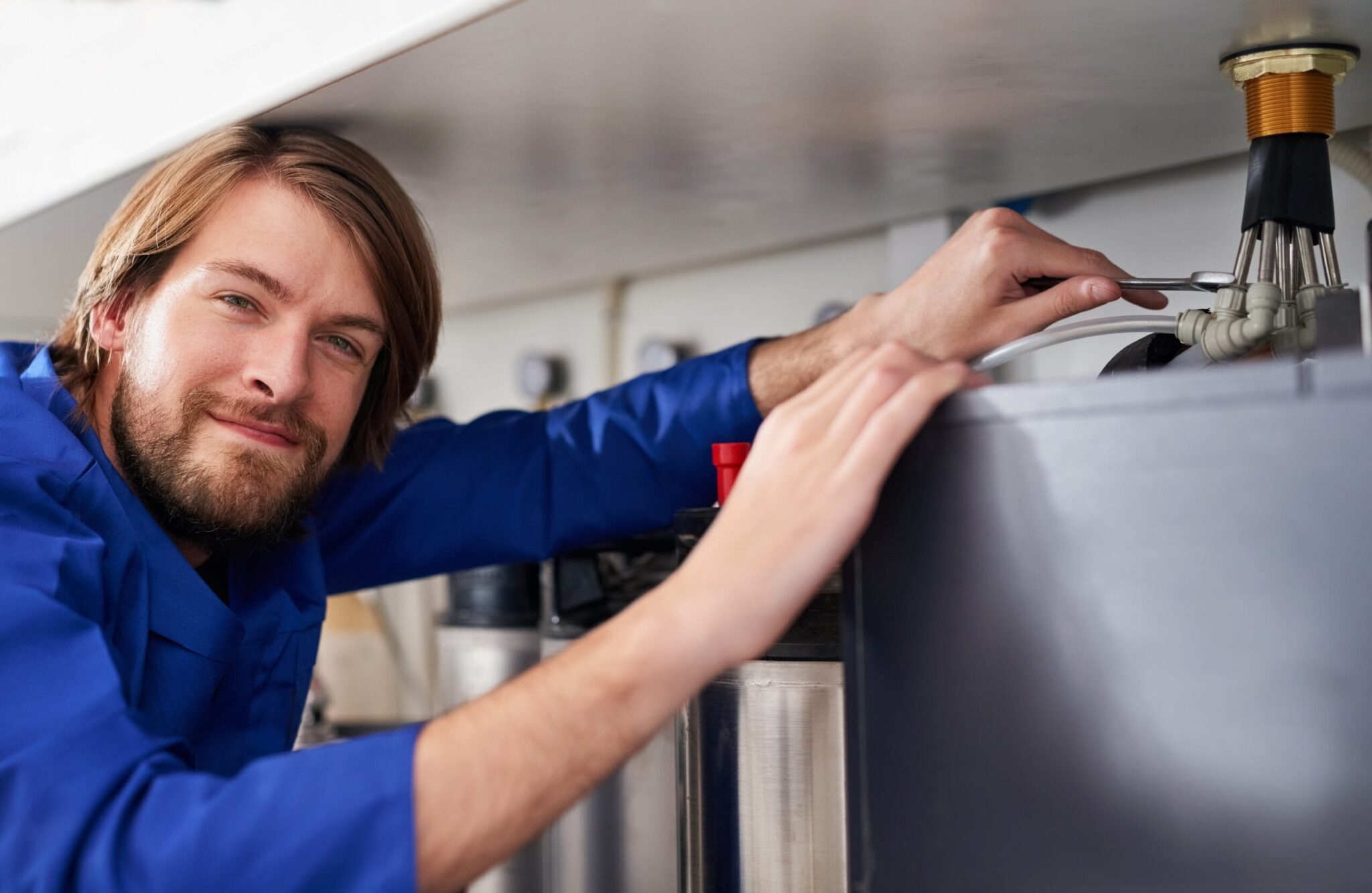 Technician servicing a residential water heater tank in Tucker