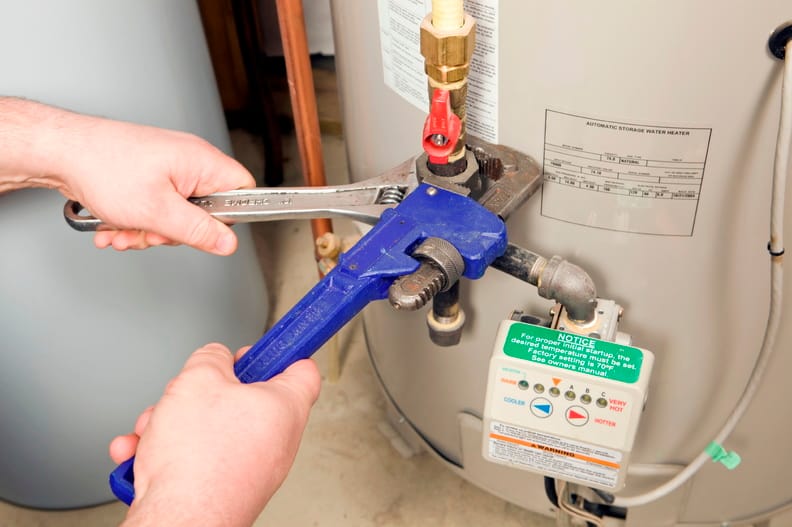 Plumber repairing a water heater valve in Tucker